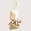 bruna taupe leather handbag on shoulder